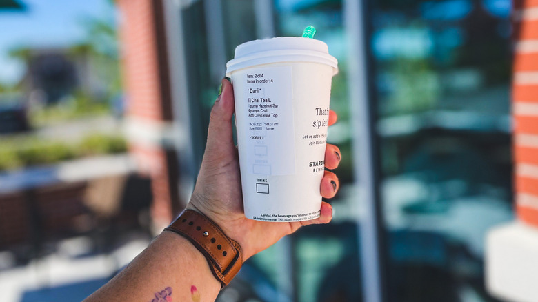 Hand holding Starbucks cup