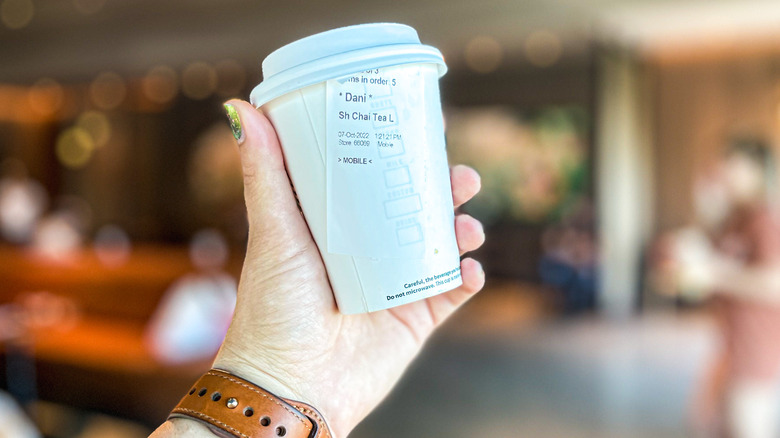 Hand holding Starbucks cup