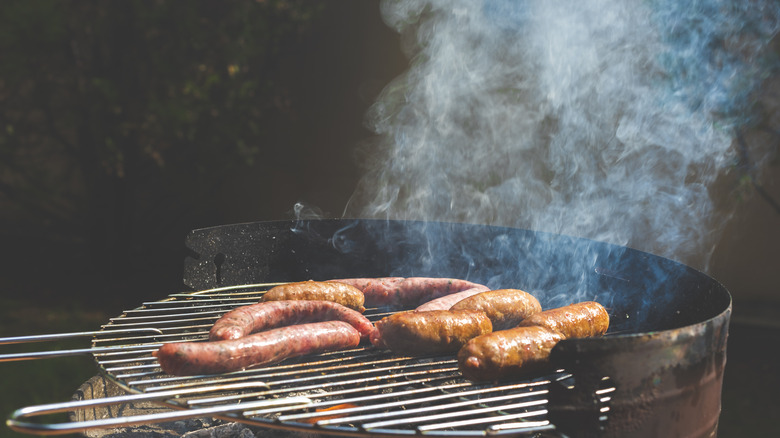 Grilling sausages over flame