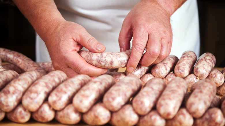 Person making sausage with hands