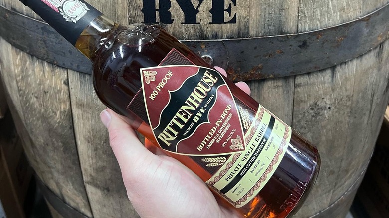 person holding rittenhouse rye bottle