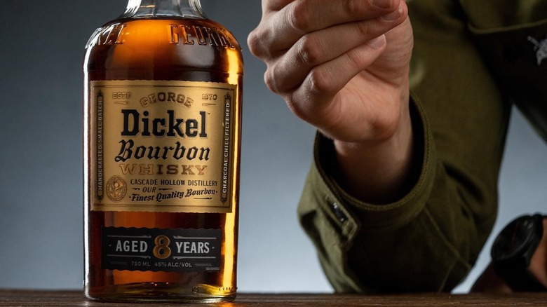 George Dickel bourbon beside man