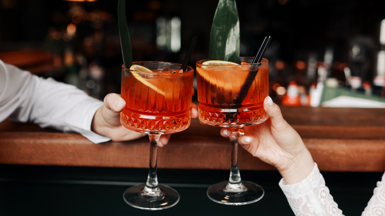 Two people holding Spritz cocktails