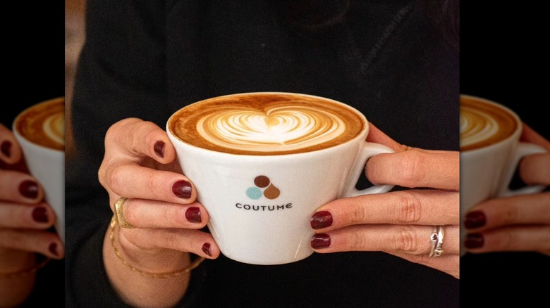 hands holding cup cappuccino 