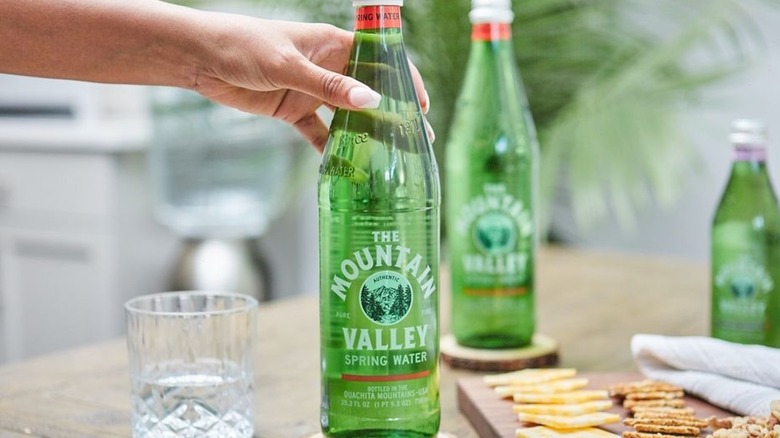 Hand reaching for green bottle 