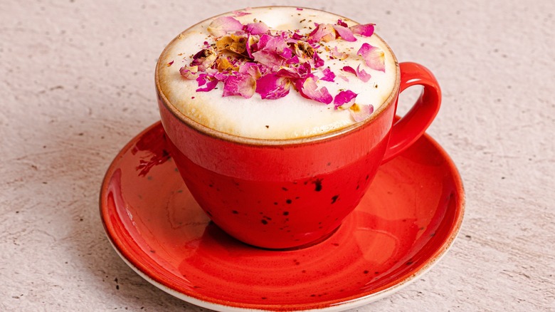 red cappuccino cup with rose petals