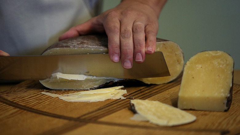 knife slicing dry jack cheese