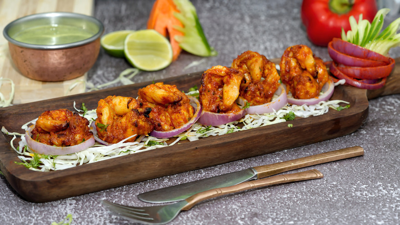 Tandoori shrimp dish with garnishes and chutney on the side