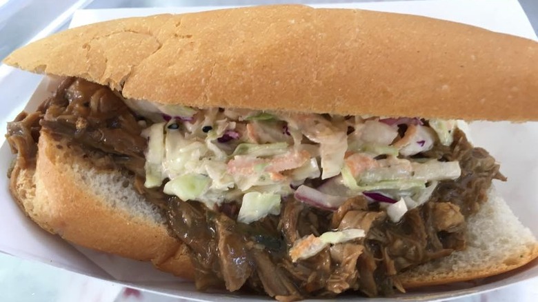 Close-up of small po'boy with pulled pork and coleslaw