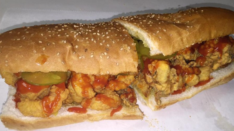 Fried shrimp po'boy with hot sauce on sesame seed bread