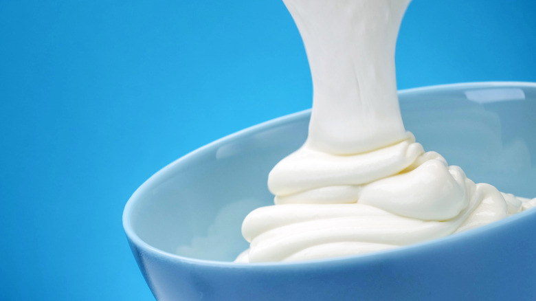 Greek yogurt pouring into bowl