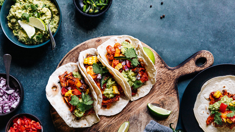 Tacos and sides on cutting board