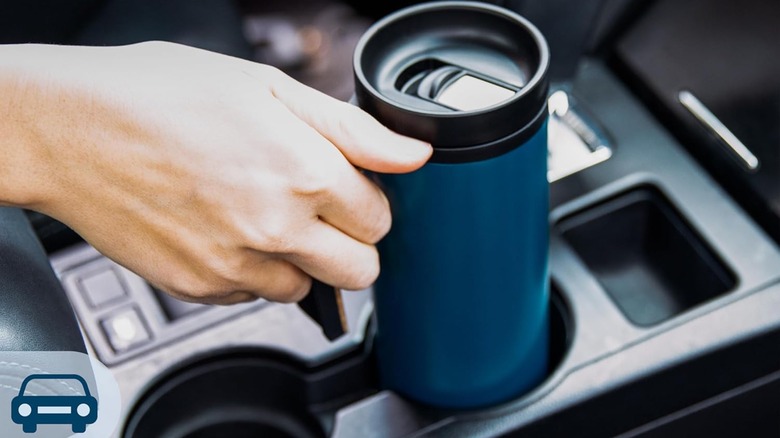 Hand putting an Ello travel mug in a car's cup holder