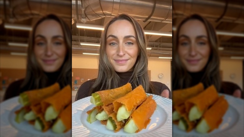 Woman holding a plate of cheese-wrapped pickles