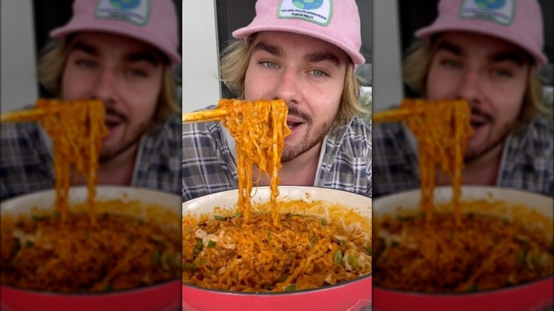 Man holding up ramen carbonara with chopsticks