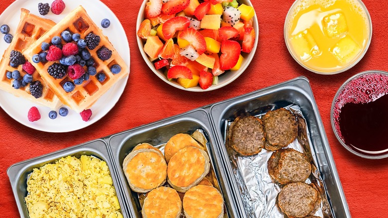 Several breakfast buffet food items and dishes against a red background