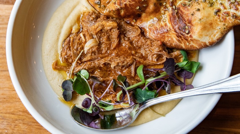 Ema's zaatar manouche, hummus with lamb Ragu, & spicy harissa