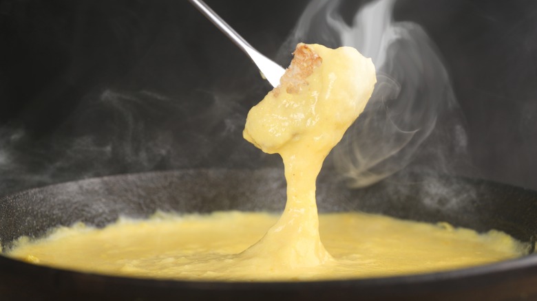 dipping bread into fondue pot