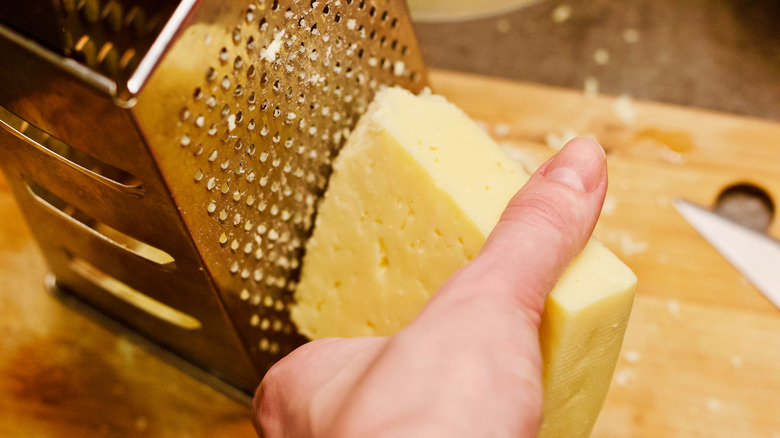 Hands grating cheese