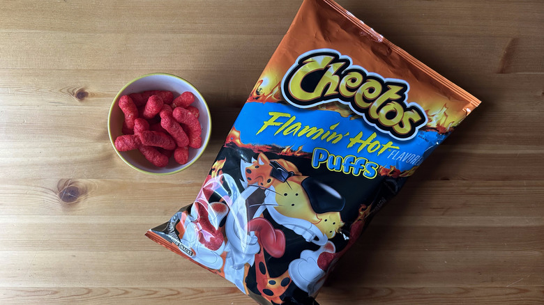 Flamin' Hot Puffs Cheetos bag with bowl on wooden table