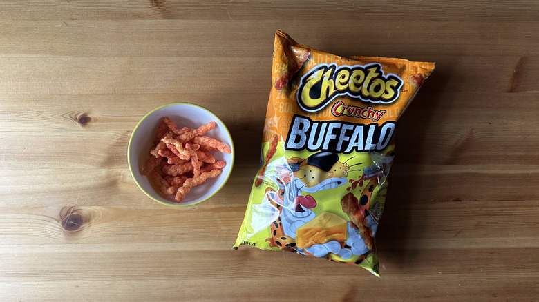 Crunchy Buffalo Cheetos bag with bowl on wooden table