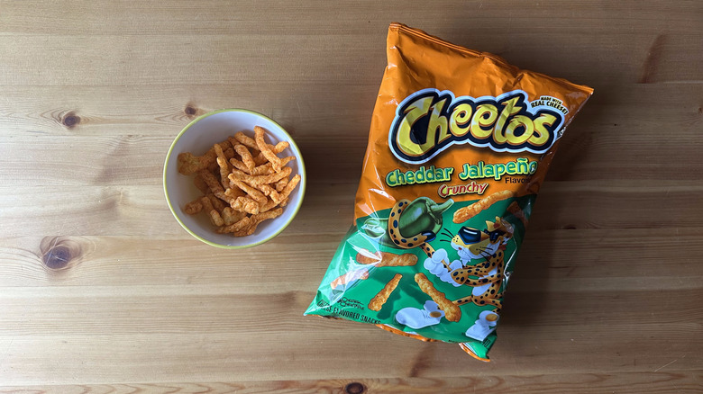 Cheddar Jalapeno Crunchy Cheetos bag with bowl on wooden table