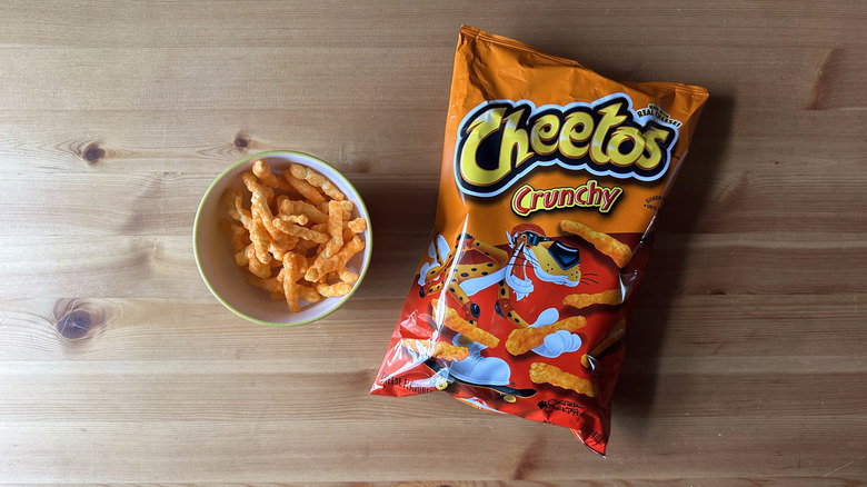 Crunchy Cheetos bag with bowl on wooden table