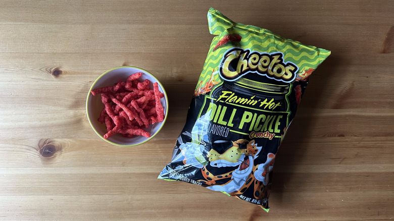Flamin' Hot Dill Pickle Crunchy Cheetos bag with bowl on wooden table