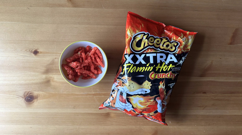 Xxtra Flamin' Hot Crunchy Cheetos bag with bowl on wooden table