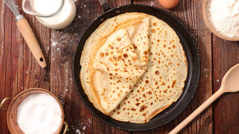 crepe in pan by wood whisk 