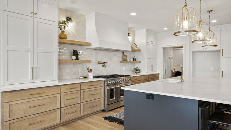 Modern white, wood, and blue kitchen with multiple light sources