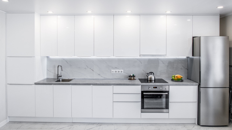 White kitchen with cabinets that have no handles