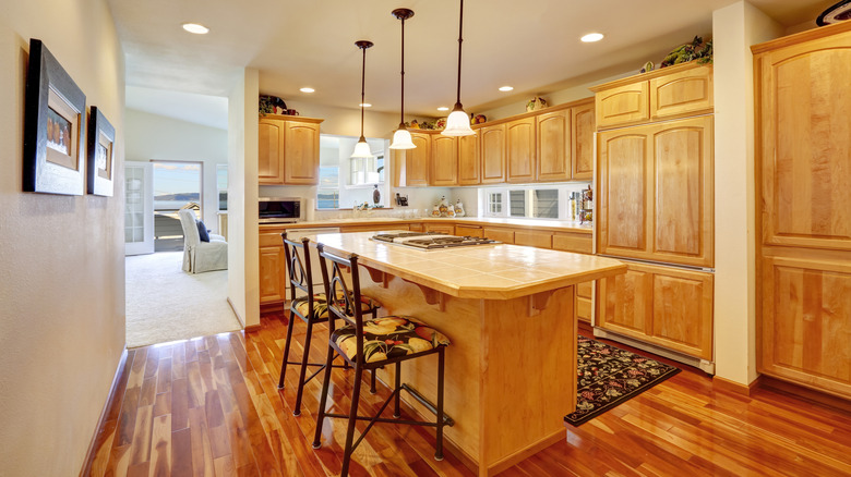 Wood kitchen with island, chairs, and tall storage units