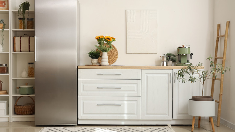 Beige kitchen counter with counter-depth stainless steel fridge