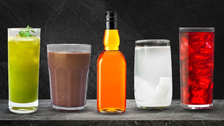 Whiskey or bourbon pouring into a glass with ice