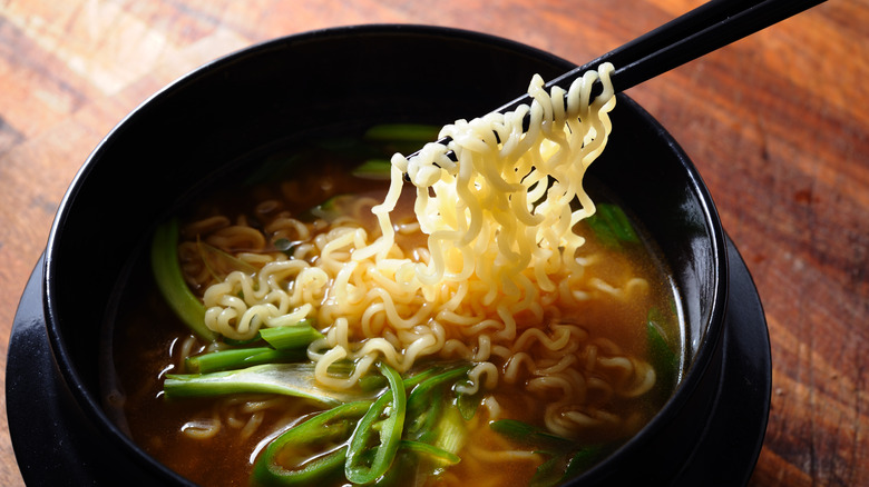 Chopstick holding up ramen noodles