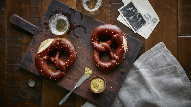 Pretzels with beer and mustard on wooden board