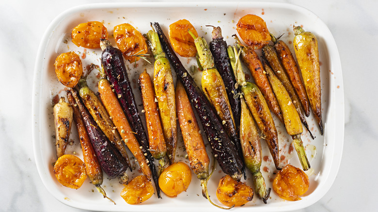 Root vegetables with a glaze in white ceramic baking dish