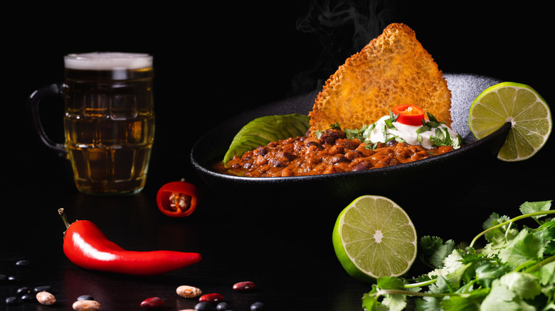 Bowl of chili next to pint of beer