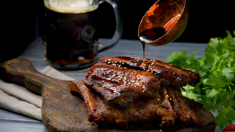 Ribs on chopping board with teriyaki and beer sauce