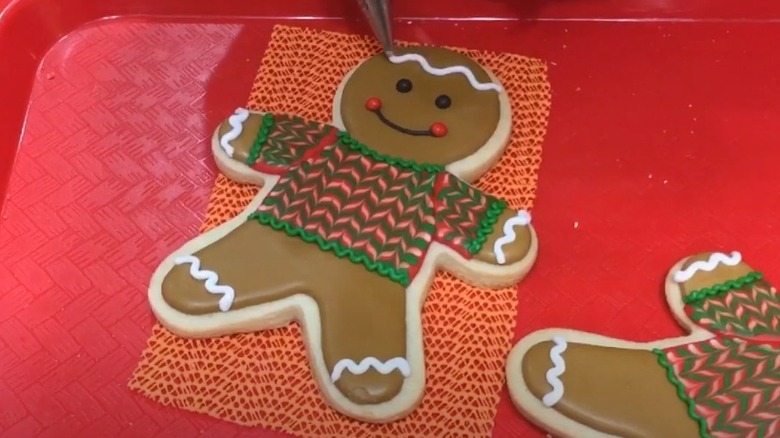 Decorating a gingerbread man with a sweater