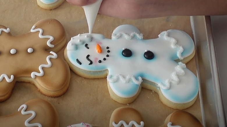 Piping icing onto gingerbread snowman