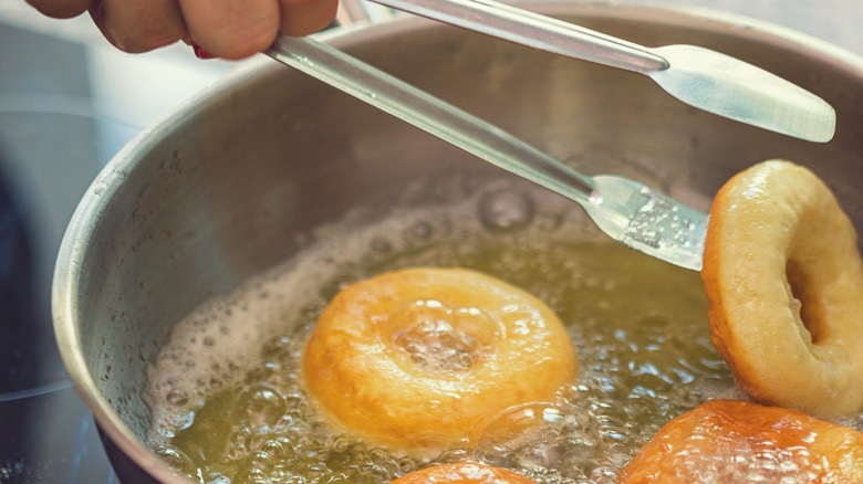 Person frying homemade donuts