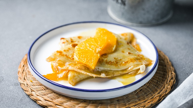 Crepes suzette topped with oranges