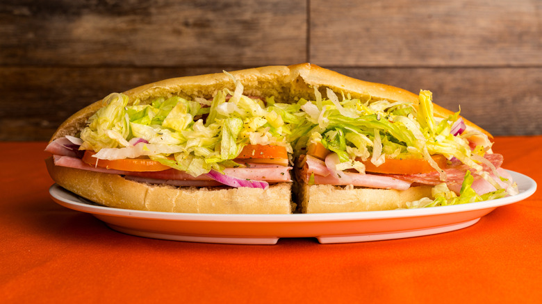 Italian sub sandwich on plate on orange table