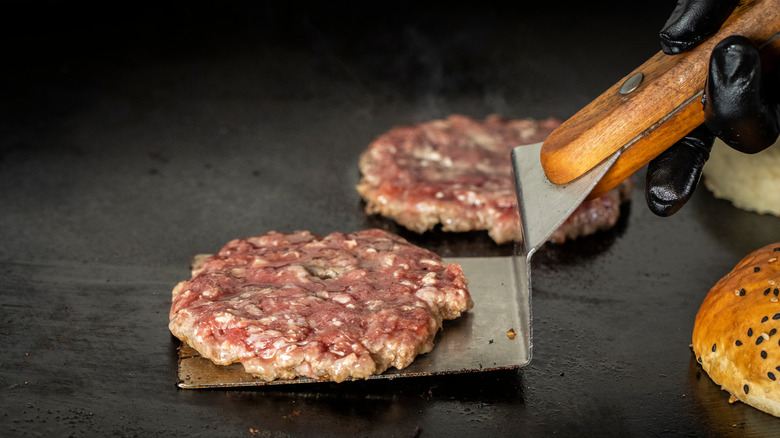 spatula lifting patty on griddle