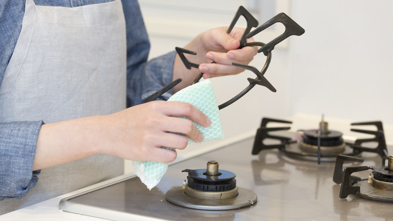 Woman cleaning burner grate