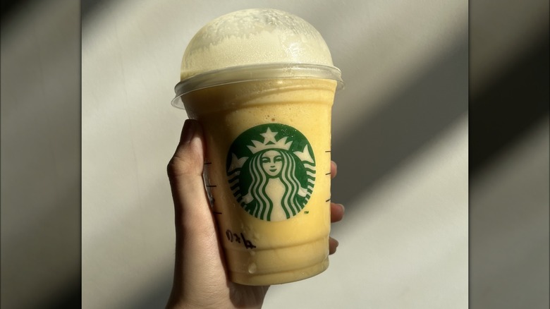 hand holding mango Frappuccino