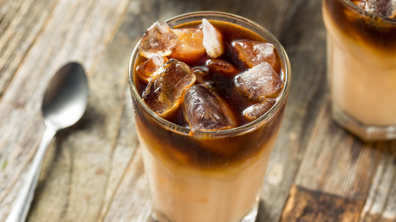 Glasses of horchata on ice with Kahlúa sitting on a table with a spoon