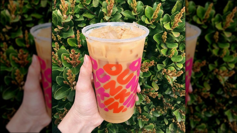 Hand holding Dunkin' iced coffee